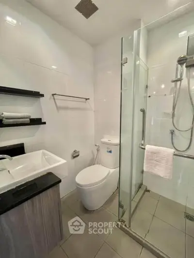 Modern bathroom with glass shower and sleek fixtures in a contemporary apartment.