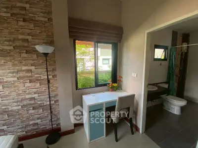Charming interior with study nook and bathroom view, featuring stylish decor and natural light.