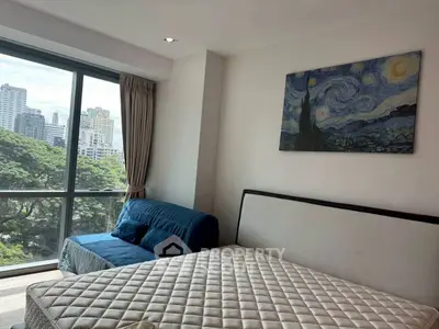 Modern bedroom with large window and city view, featuring stylish decor and comfortable furnishings.