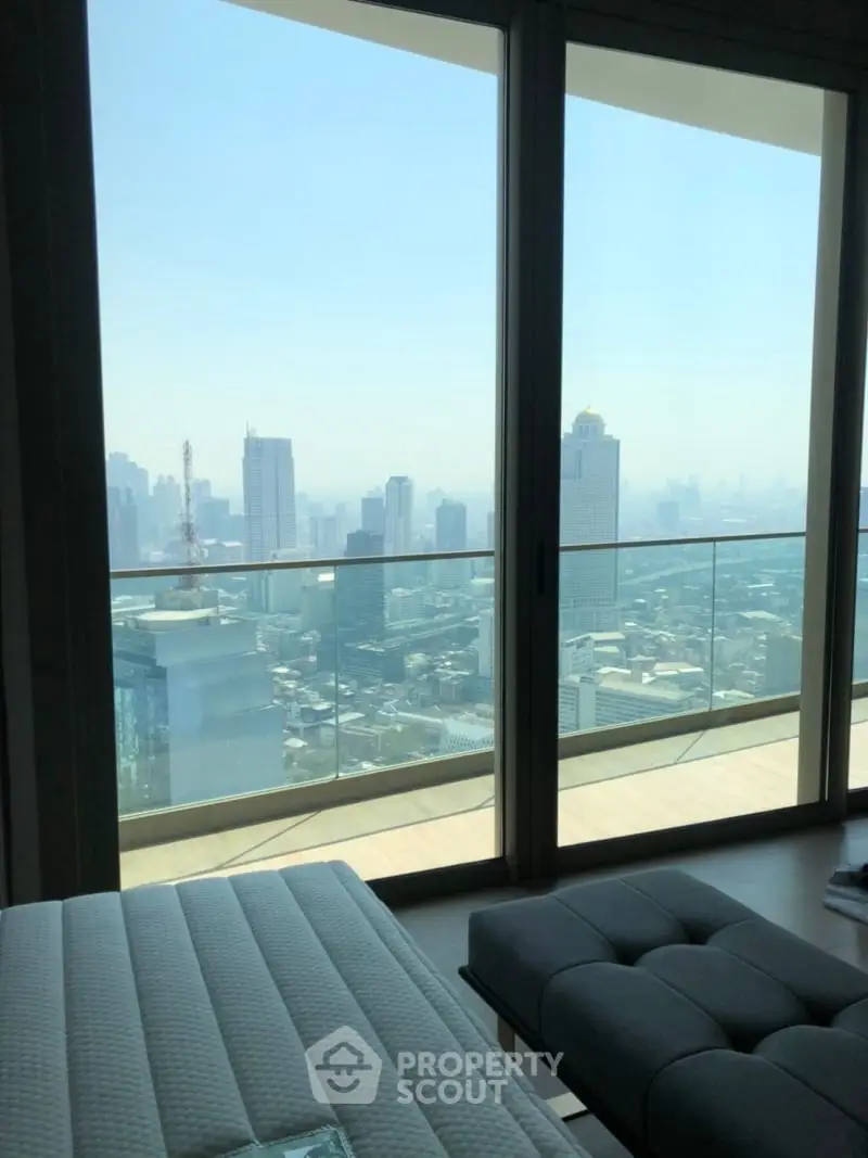 Luxurious high-rise apartment with stunning city skyline view from spacious balcony.