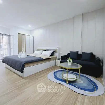 Spacious modern bedroom with elegant decor and cozy seating area