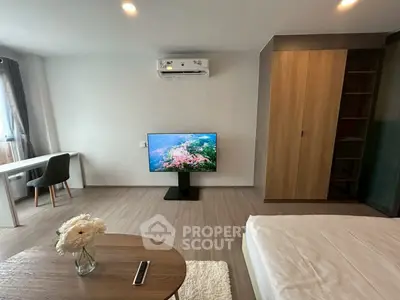 Modern bedroom with TV, air conditioning, and stylish furniture