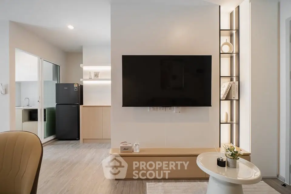 Modern living room with sleek TV setup and open kitchen layout