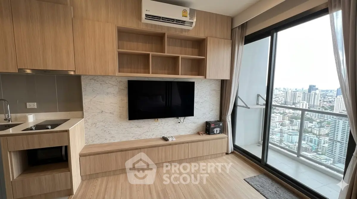 Modern living room with city view balcony, featuring built-in wooden cabinetry and sleek TV setup.
