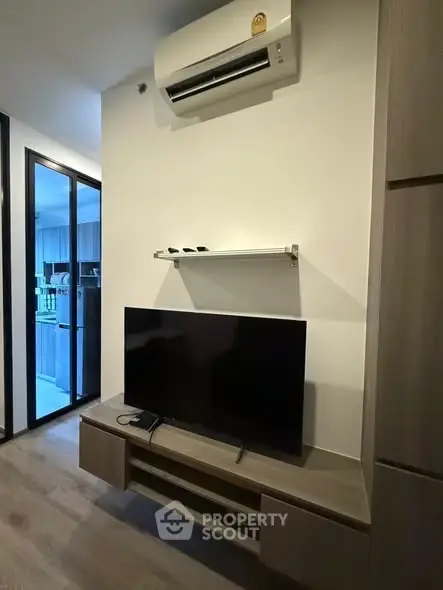 Modern living room with sleek TV setup and air conditioning unit