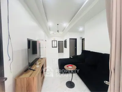 Spacious modern living room with sleek black sofa and elegant decor