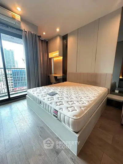 Modern bedroom with large window and city view, featuring stylish decor and natural light.