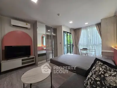 Modern studio apartment with stylish decor and large windows for natural light.