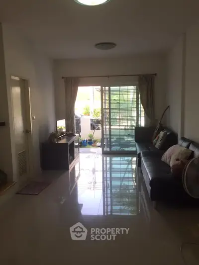 Spacious living room with natural light and balcony access in modern apartment.