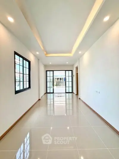 Spacious modern living room with large windows and sleek tile flooring