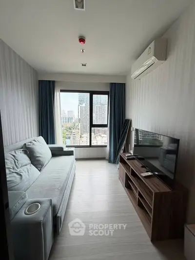 Modern living room with city view, featuring a sleek sofa and entertainment unit, perfect for urban living.