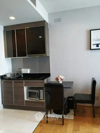 Modern kitchen with sleek cabinetry and dining area in stylish apartment