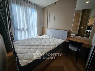 Modern bedroom with large window and stylish furniture in a cozy apartment.