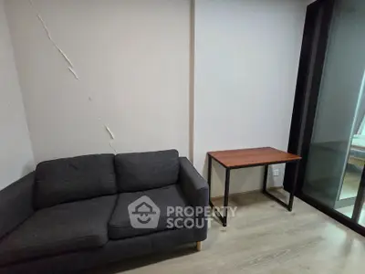 Cozy living room with modern gray sofa and sleek wooden table, perfect for minimalist style.