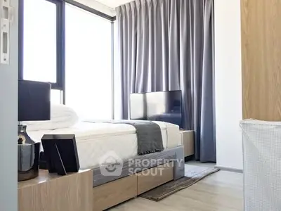 Modern bedroom with large windows and stylish decor, featuring a cozy bed and elegant furnishings.