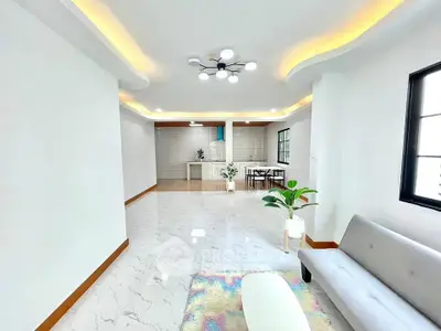 Spacious modern living room with elegant lighting and open kitchen layout