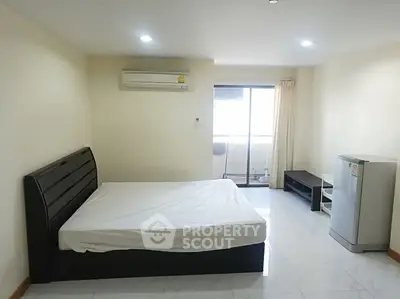 Spacious bedroom with modern furnishings and balcony access