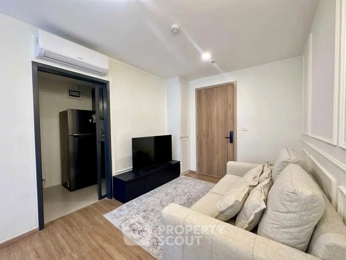 Modern living room with cozy sofa and sleek TV setup in a stylish apartment.