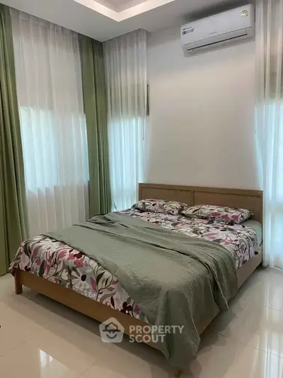 Cozy bedroom with modern air conditioning and stylish floral bedding, perfect for relaxation.