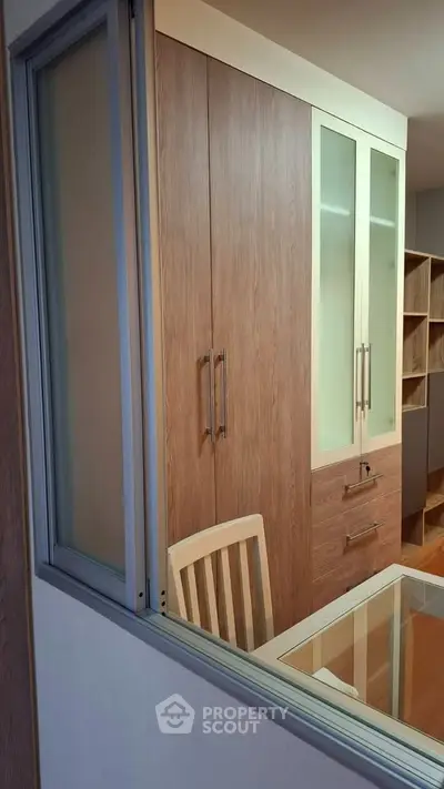 Modern study room with wooden cabinets and glass-top desk