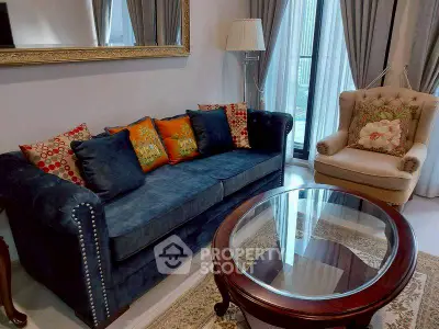 Elegant living room with plush blue sofa, armchair, and glass coffee table, perfect for cozy gatherings.