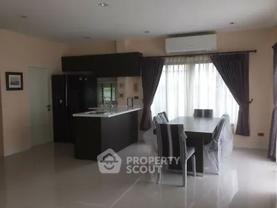 Modern dining area with sleek kitchen and large window, perfect for family gatherings.