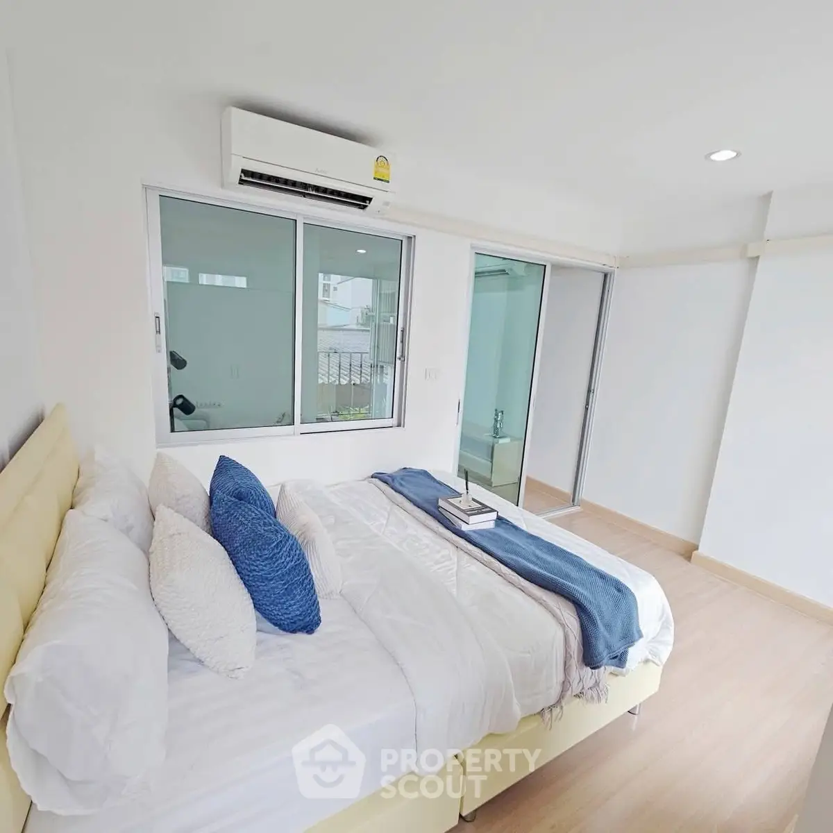 Bright and airy bedroom with modern decor and large window for natural light.
