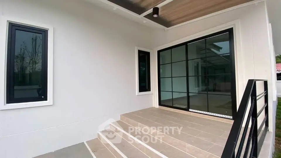 Modern home entrance with sleek glass doors and steps