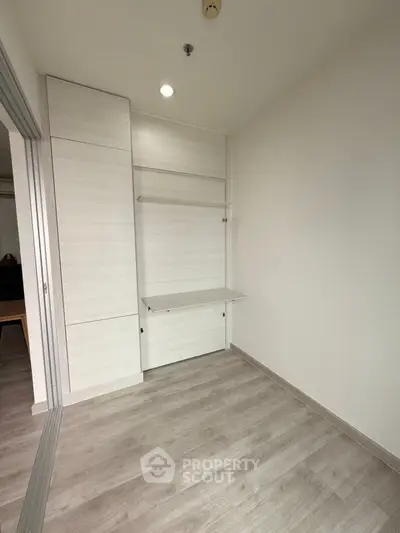 Minimalist study room with foldable desk and light wood flooring