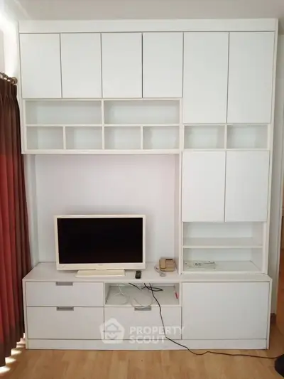 Modern living room with sleek white built-in storage and entertainment unit.