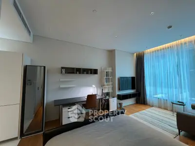 Modern bedroom with study area and large window, featuring sleek furniture and natural light.