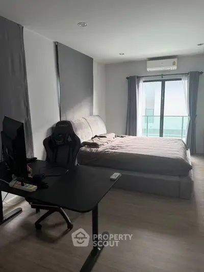 Modern bedroom with workspace and natural light, featuring sleek design and cozy ambiance.