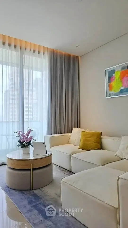 Modern living room with elegant decor and large windows offering city views.