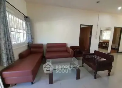 Spacious living room with modern leather sofas and glass coffee table, perfect for relaxation and entertaining.