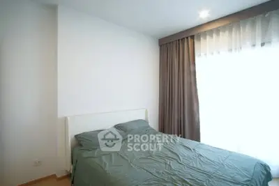 Cozy bedroom with natural light and elegant curtains in modern apartment.