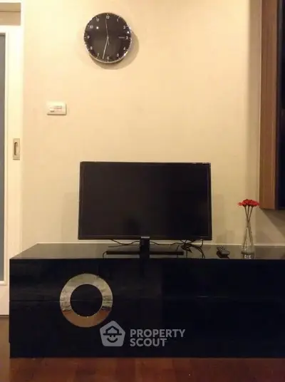Modern living room with sleek black TV stand and wall clock, perfect for contemporary home decor.