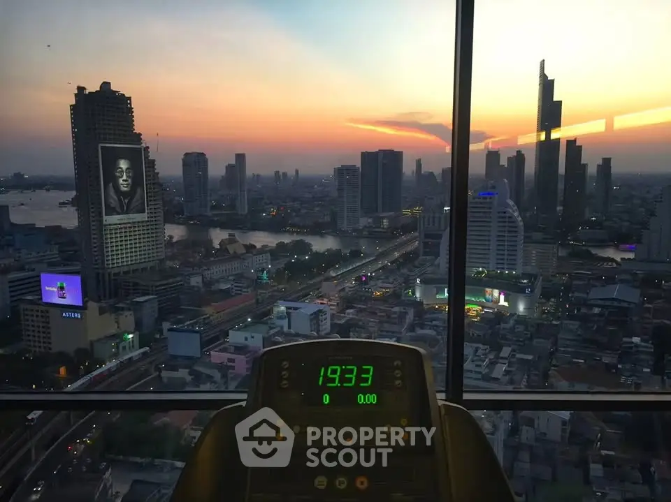 Stunning cityscape view from a high-rise gym with sunset skyline and modern skyscrapers.