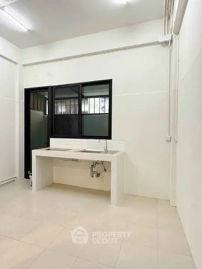 Minimalist kitchen with tiled countertop and sink in modern apartment