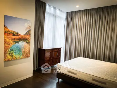 Spacious bedroom with elegant curtains and scenic wall art, featuring a comfortable bed and classic wooden dresser.