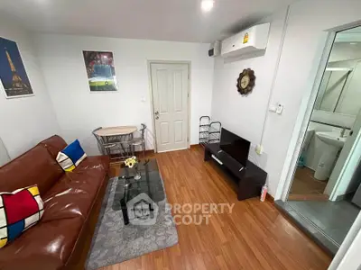 Cozy living room with brown leather sofa, modern decor, and wooden flooring.