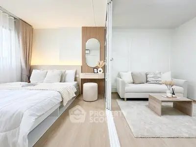 Modern bedroom with cozy living area, stylish decor, and natural light.