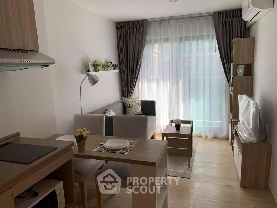 Cozy modern living room with natural light and stylish furniture in a compact apartment.