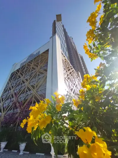 Stunning modern high-rise building with unique architectural design and vibrant garden flowers
