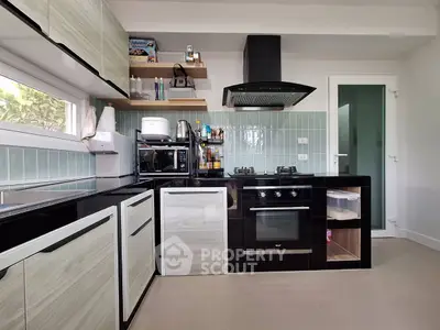 Modern kitchen with sleek cabinetry, gas stove, and built-in oven in a stylish home.