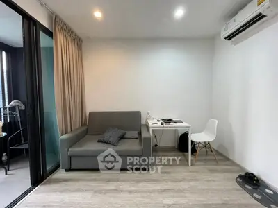 Modern living room with gray sofa, study desk, and balcony access