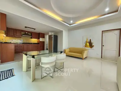 Spacious open-plan living room with modern kitchen and elegant ceiling design.