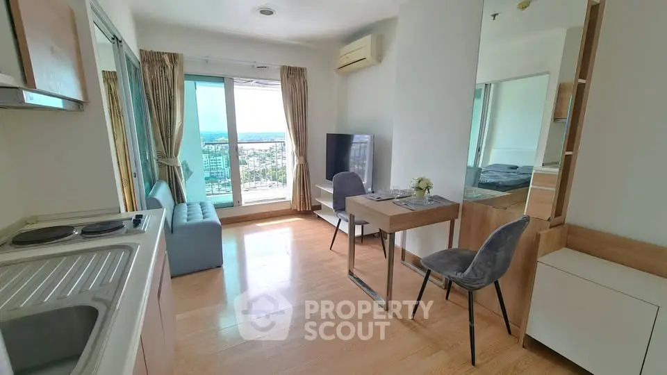 Bright modern living room with open kitchen and stunning city view from balcony.