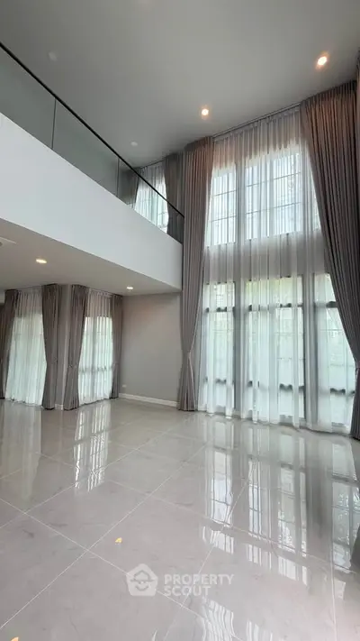 Spacious modern living room with high ceilings and large windows for natural light.