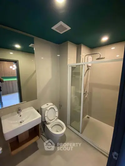 Modern bathroom with sleek shower enclosure and stylish fixtures in contemporary apartment.
