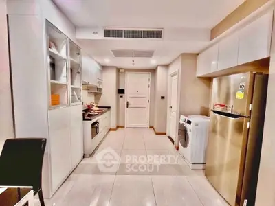 Modern kitchen with sleek appliances and ample storage in a stylish apartment.